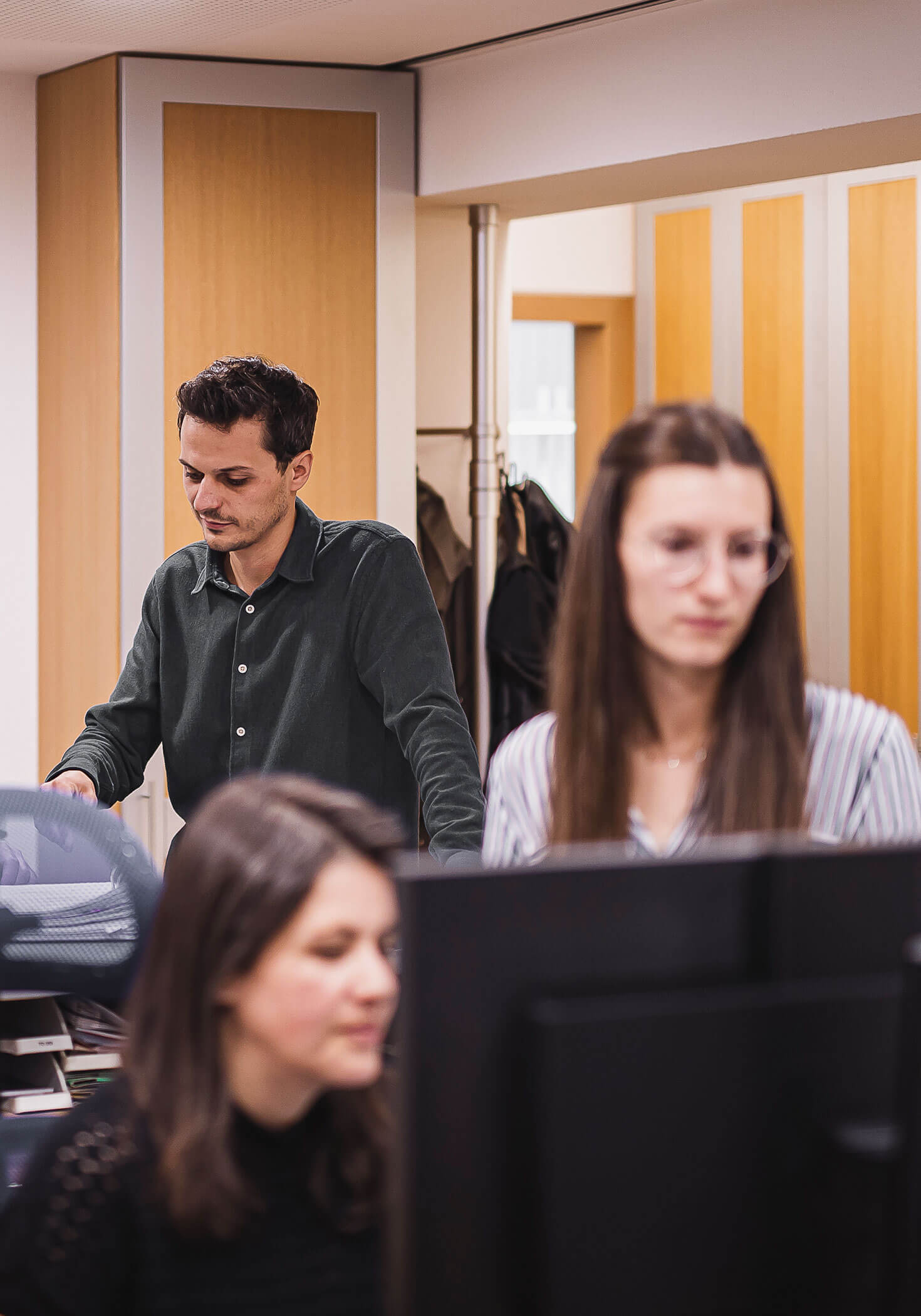 Tre dipendenti al lavoro in ufficio e al PC - Elaborazione dati Steger